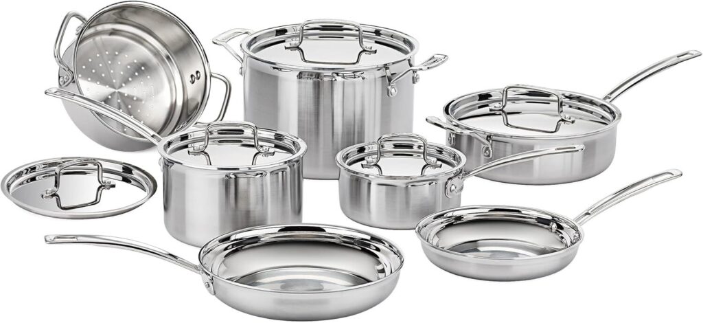 Stainless steel cookware set with saucepans and frying pans on kitchen counter