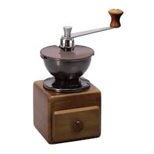 Manual coffee grinder with freshly roasted coffee beans on a kitchen counter