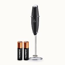 Handheld milk frother creating foam for a latte