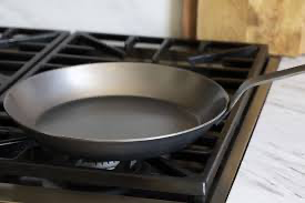 Carbon steel frying pan cooking food over high heat